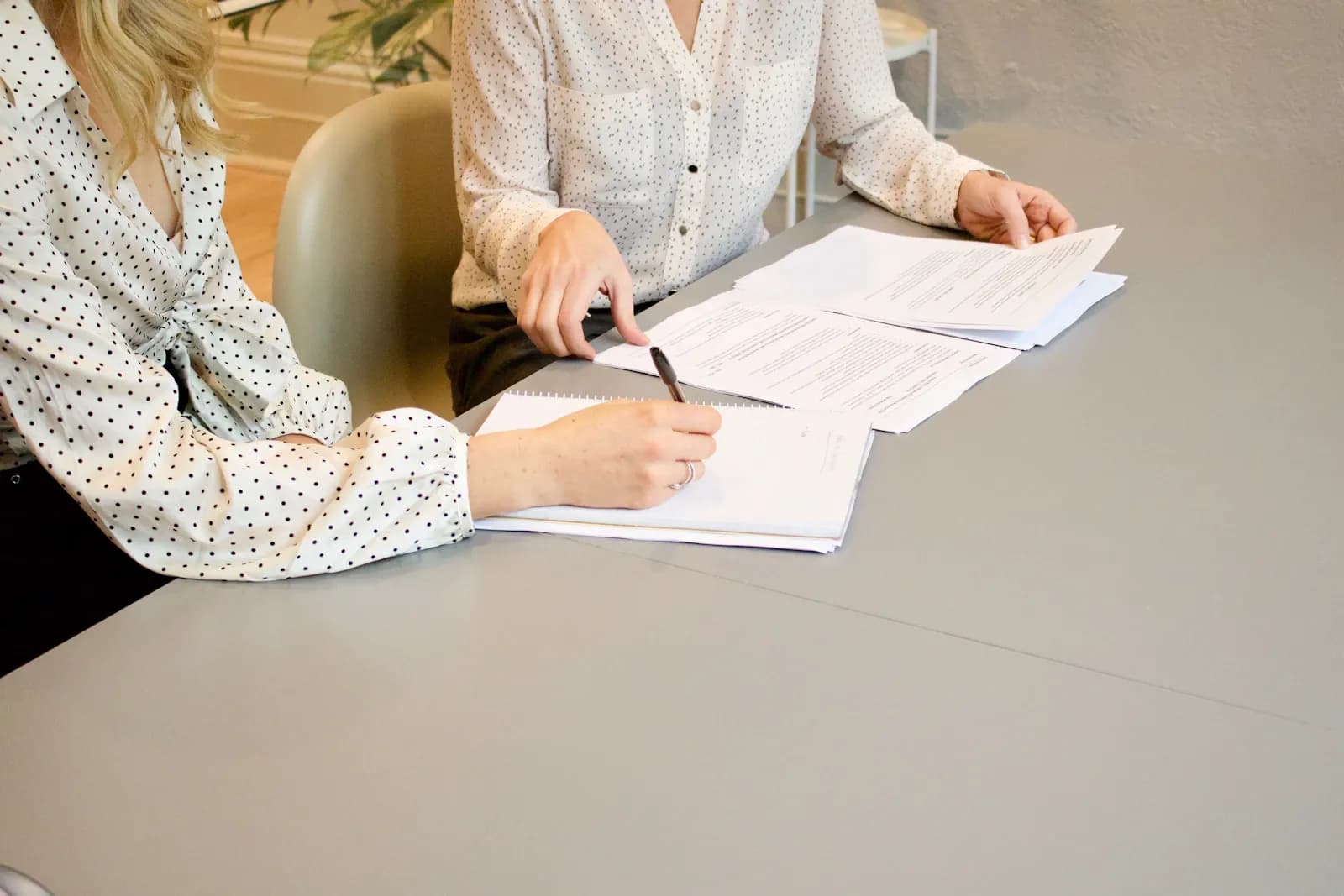 Two reviewers going through vendor assessment paperwork and signing off findings